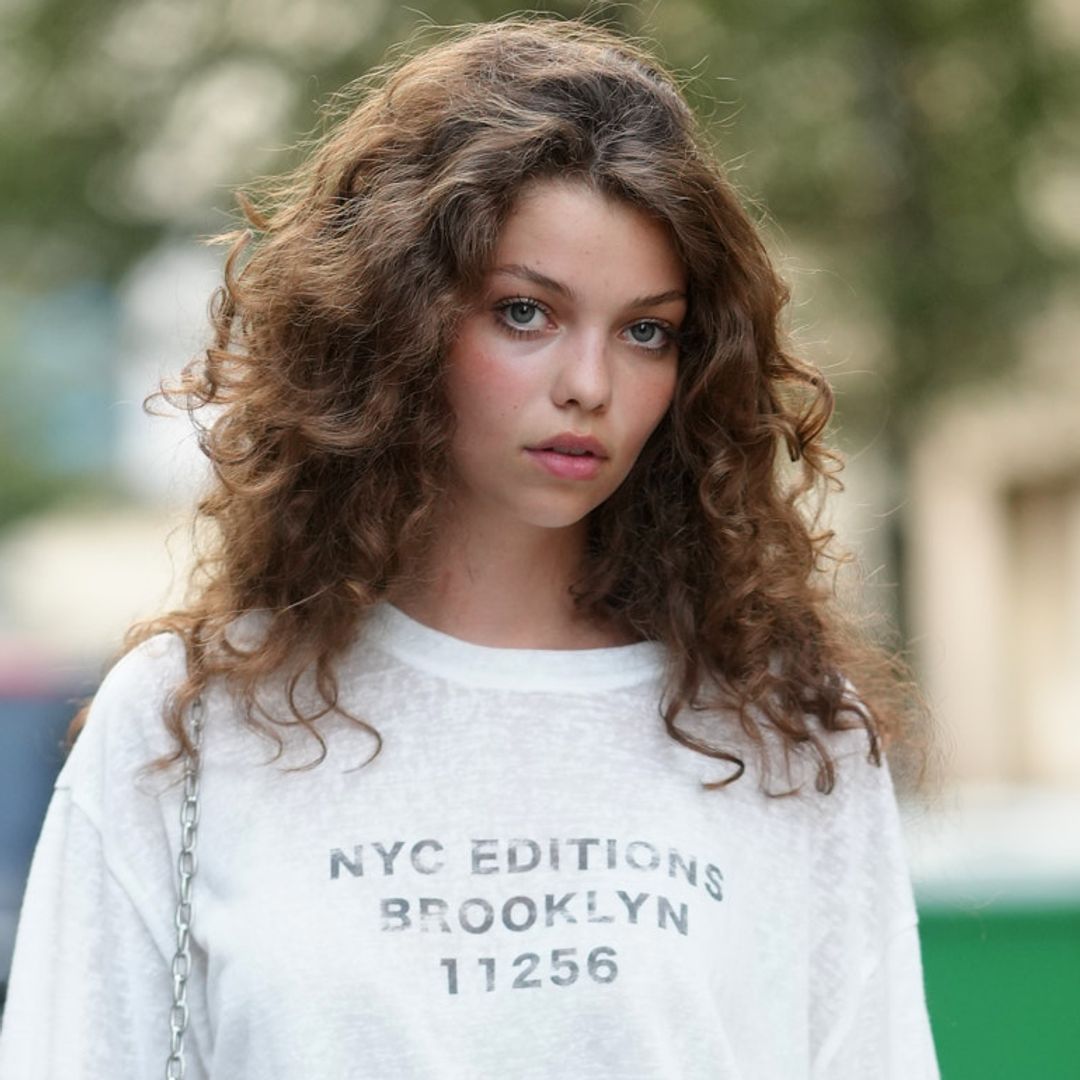 Invitada a la Semana de la Moda de París con pelo rizado y camiseta de manga larga