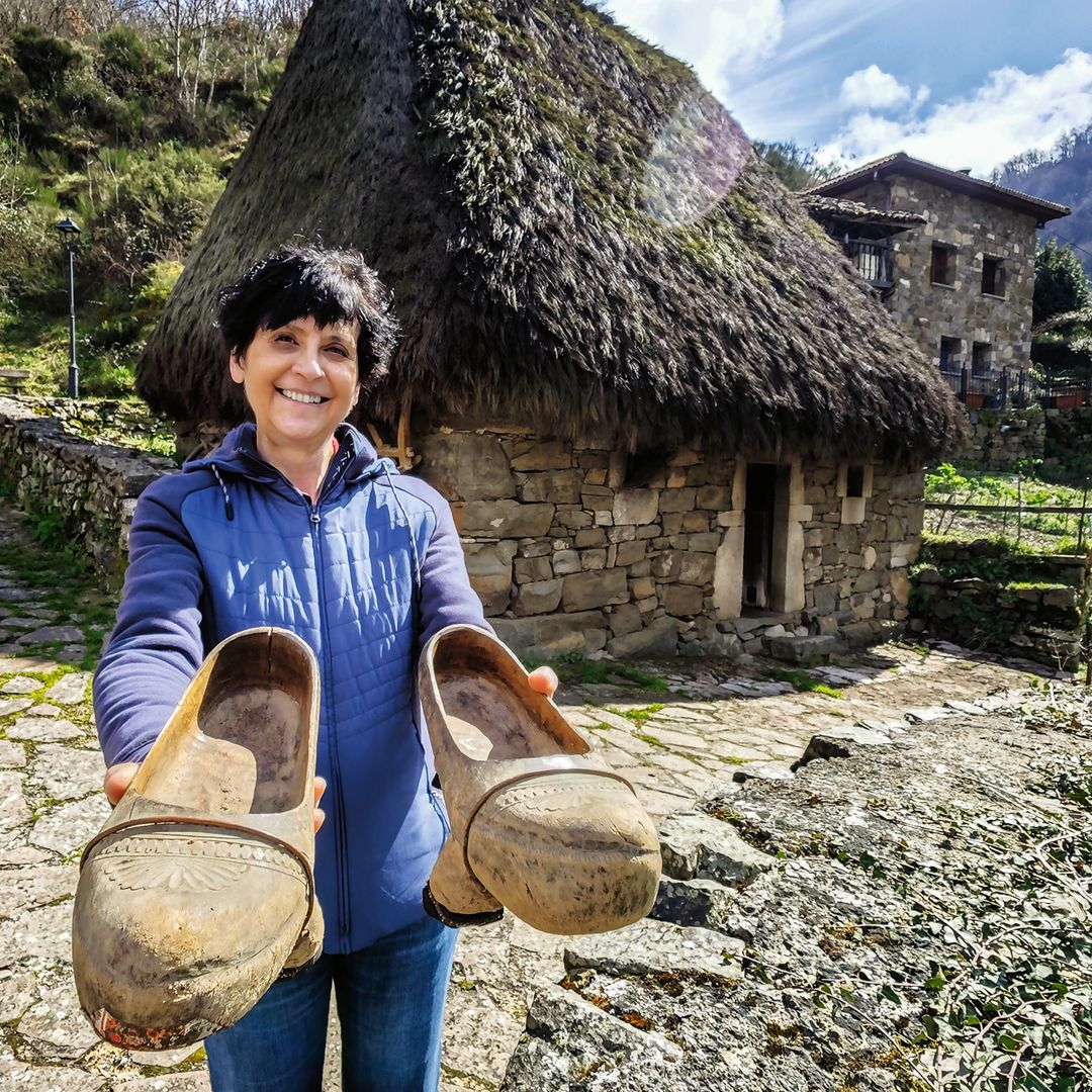 Marité Lana, responsable del ecomuseo de Somiedo, delante de una de las casas de 'teito' de Veigas, Asturias.