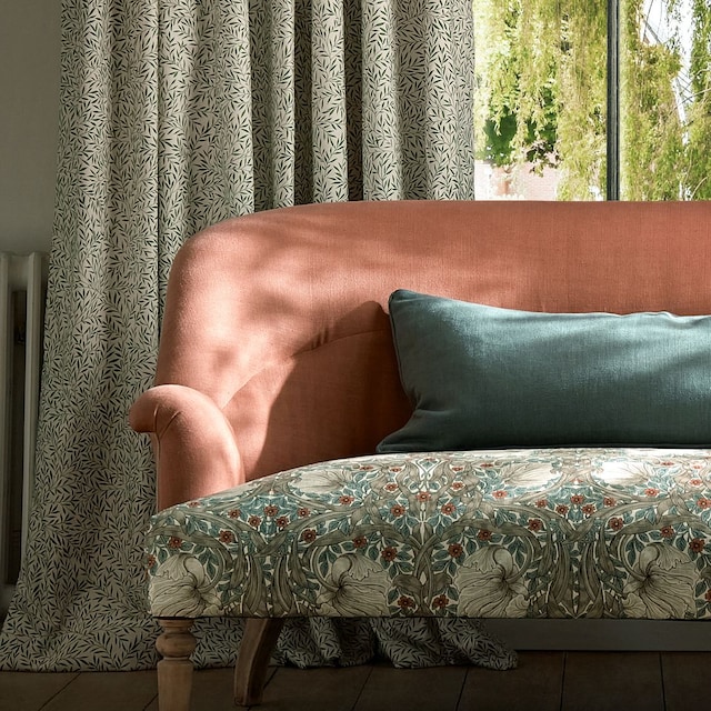 Sofá delante de cortinas verdes