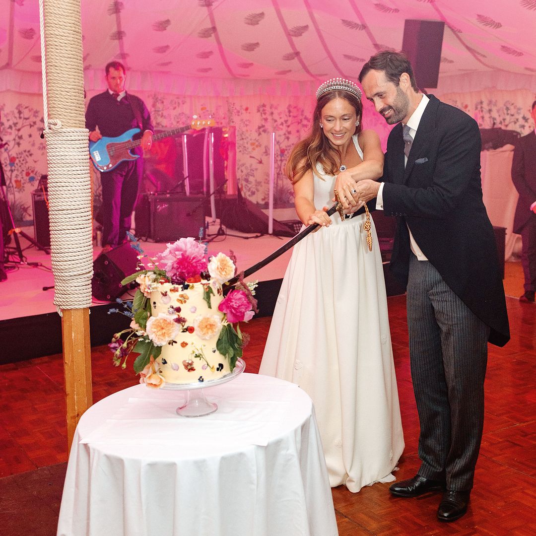 Los novios, en una bonita fotografía mientras cortan  juntos la tarta nupcial