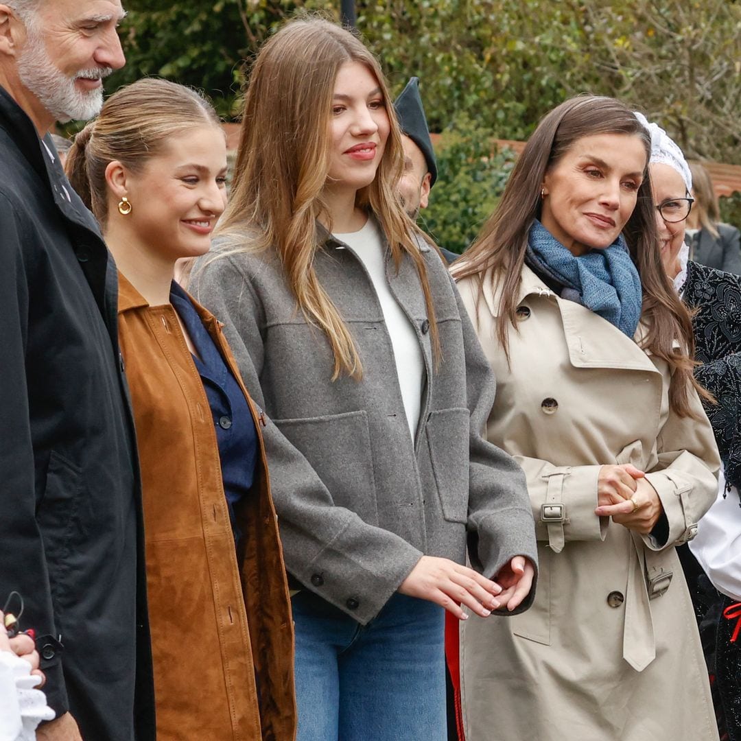 La reina Letizia se coordina con sus hijas y luce un look 'denim' con gabardina clásica
