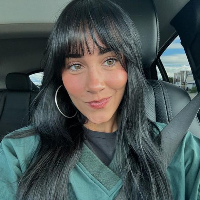 Selfie de Aitana en un coche con bomber verde y pendientes aro