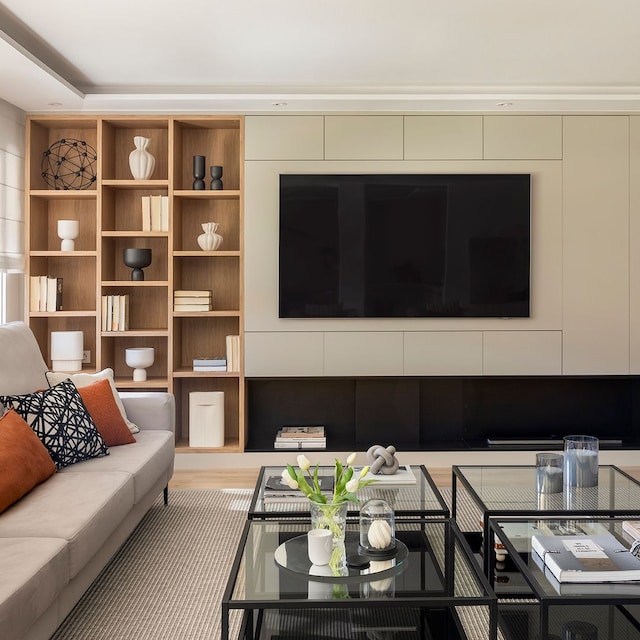 Salón con gran mueble a medida con televisión colgada y parte de baldas abiertas