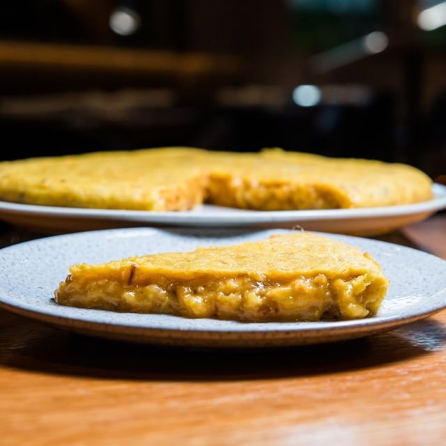 Pincho de tortilla y tortilla entera detrás de Colósimo y Menudeo