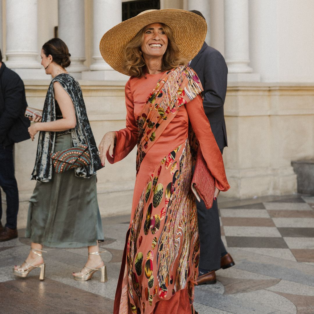 El look más comentado de esta boda en Sevilla fue el de la madre de la novia, con vestido coral asimétrico y pamela de rafia