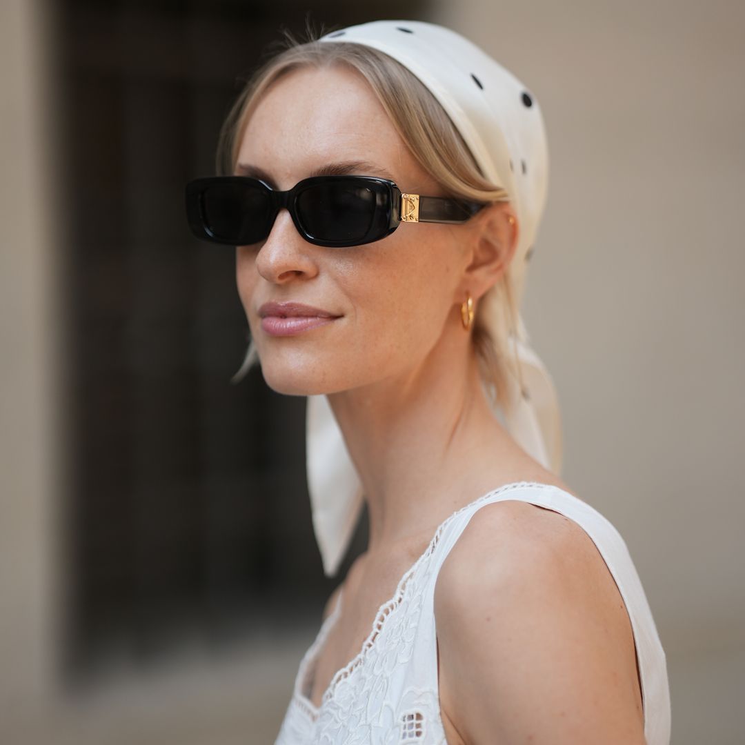 Mujer rubia con pañuelo blanco y gafas de sol