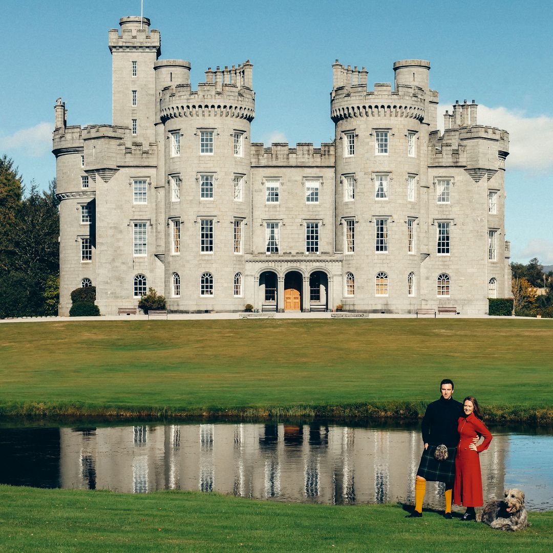 Cosmo y Bronya posan con "Grimsby" su lobero irlandés, ante la imponente fachada del castillo de Cluny, su hogar; una propiedad que consta de 100 habitaciones y que parece salida de un cuento, con sus torreones, extensos jardines, un lago y una capilla histórica