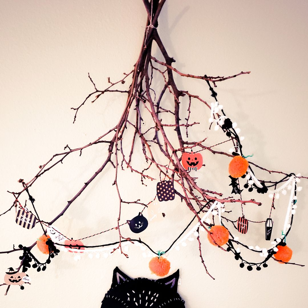 Manualidades de Halloween. Ramas de árbol con elementos de Halloween colgados.