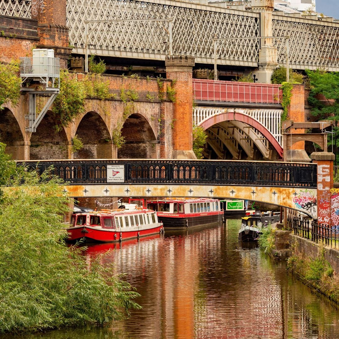 Pasarela que cruza el canal Bridgewater, con Castlefield y el viaducto Bridgewater al fondo, Manchester, Inglaterra