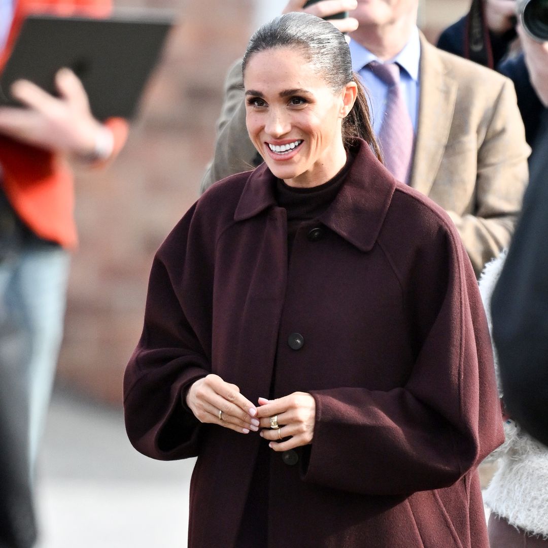 Meghan Markle, pura elegancia en su vuelta a Inglaterra con un look que resume las tendencias de otoño: tonos berenjena, falda midi y abrigo de manga ancha