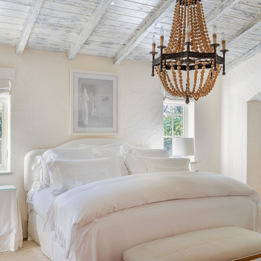 El dormitorio principal, en tonos blancos, como el resto de la casa, que destaca por su estética elegante y original. En la pared, junto a la cama, la fotografía "Size 0", de su serie de fotografías titulada "Too Good to Be True"