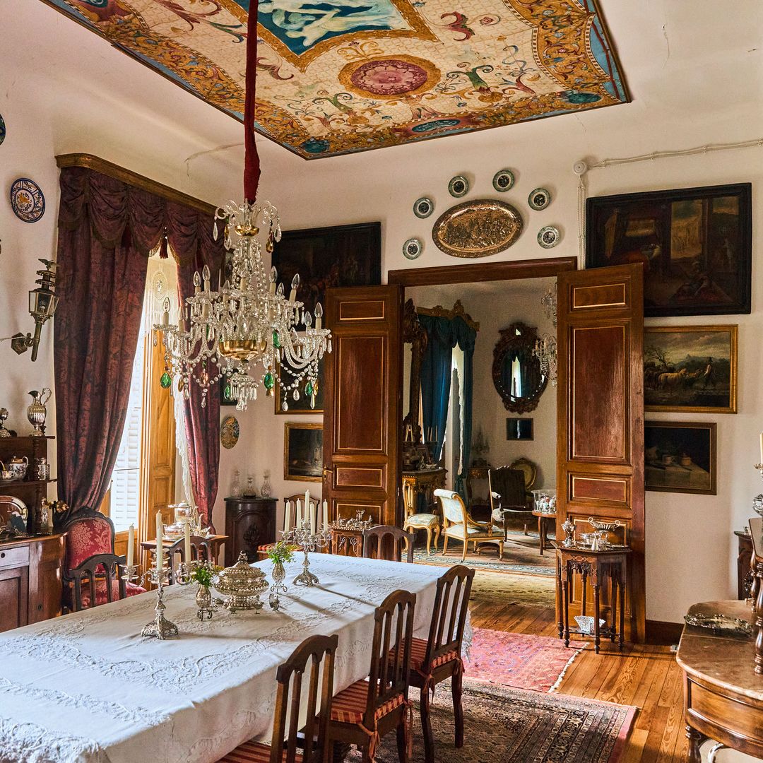 Otra foto del mismo espacio, cuyo techo está decorado con un lienzo pompeyano de principios del siglo XIX y lámparas de cristal de la época. 