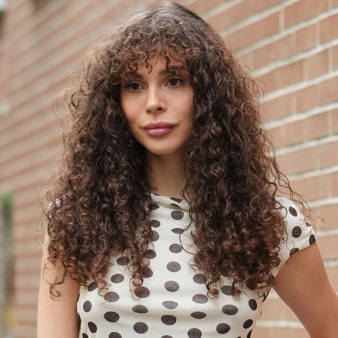 Invitada a la Semana de la Moda de Milán con melena rizada y camiseta estampada