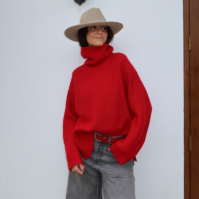 Plano medio de Victoria de Marichalar con jeans wide leg grises y jersey rojo con sombrero