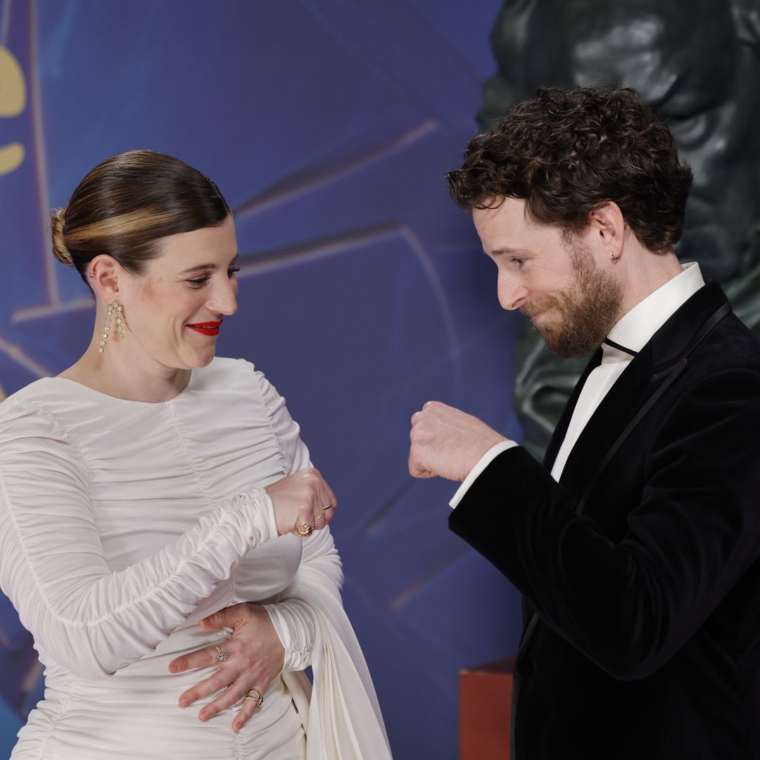 Álvaro y Ángela Cervantes posing bumping elbows on a red carpet during the Goya Awards 2026 in Barcelona, Spain, on Saturday, 28 February 2026.