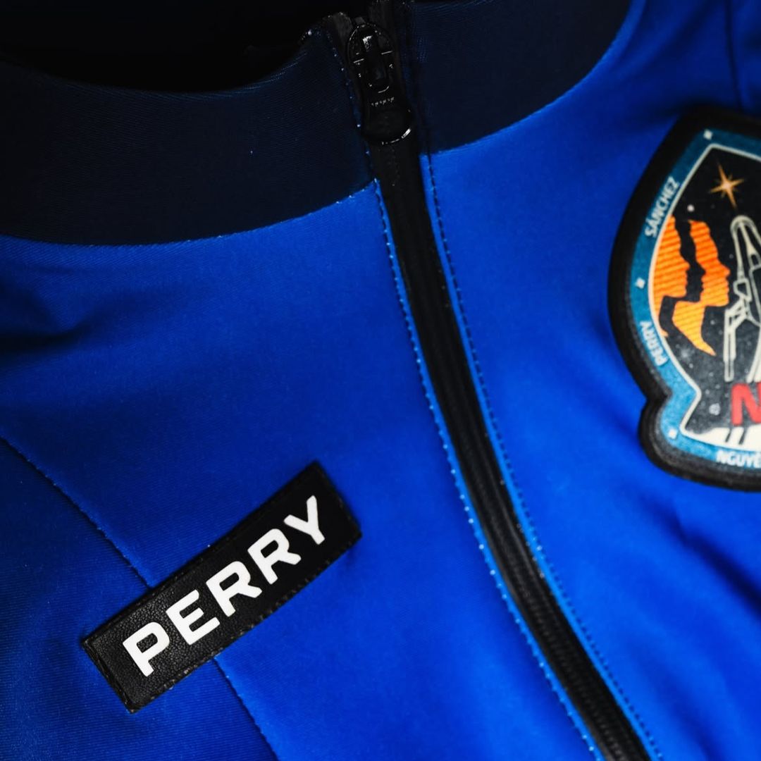 Vistazo de cerca a los detalles del traje espacial con la etiqueta del nombre, la cremallera y el escudo bordado.