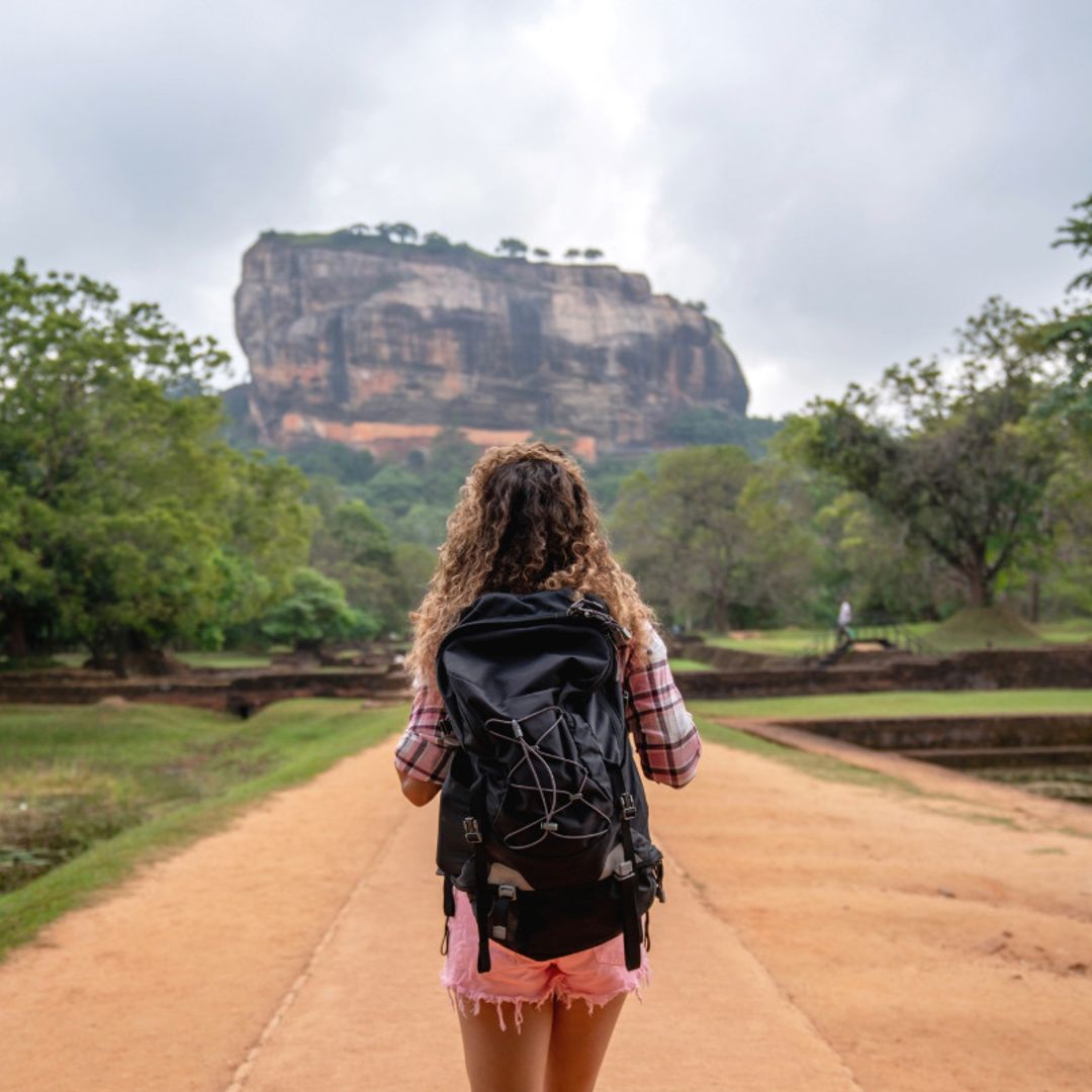 Mujer mochilera caminando hacia el templo de la roca de Sigiriya en Sri Lanka