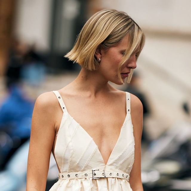 Mujer con corte de pelo bob y vestido blanco de escote en V