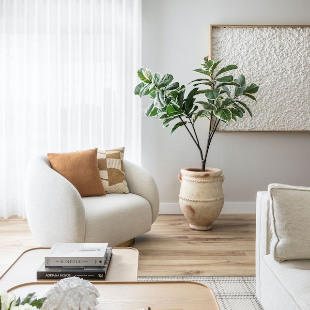 Salón con butaca blanca y planta
