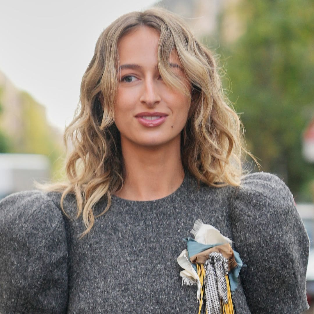  Izzi Poopi en la Semana de la Moda de Milán con vestido gris acolchado y pelo rizado