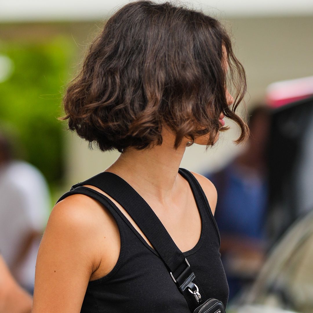 Chica con corte bob ondulado y backpack de Prada en Cannes