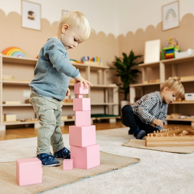 Niños en clase jugando con elementos de Montessori
