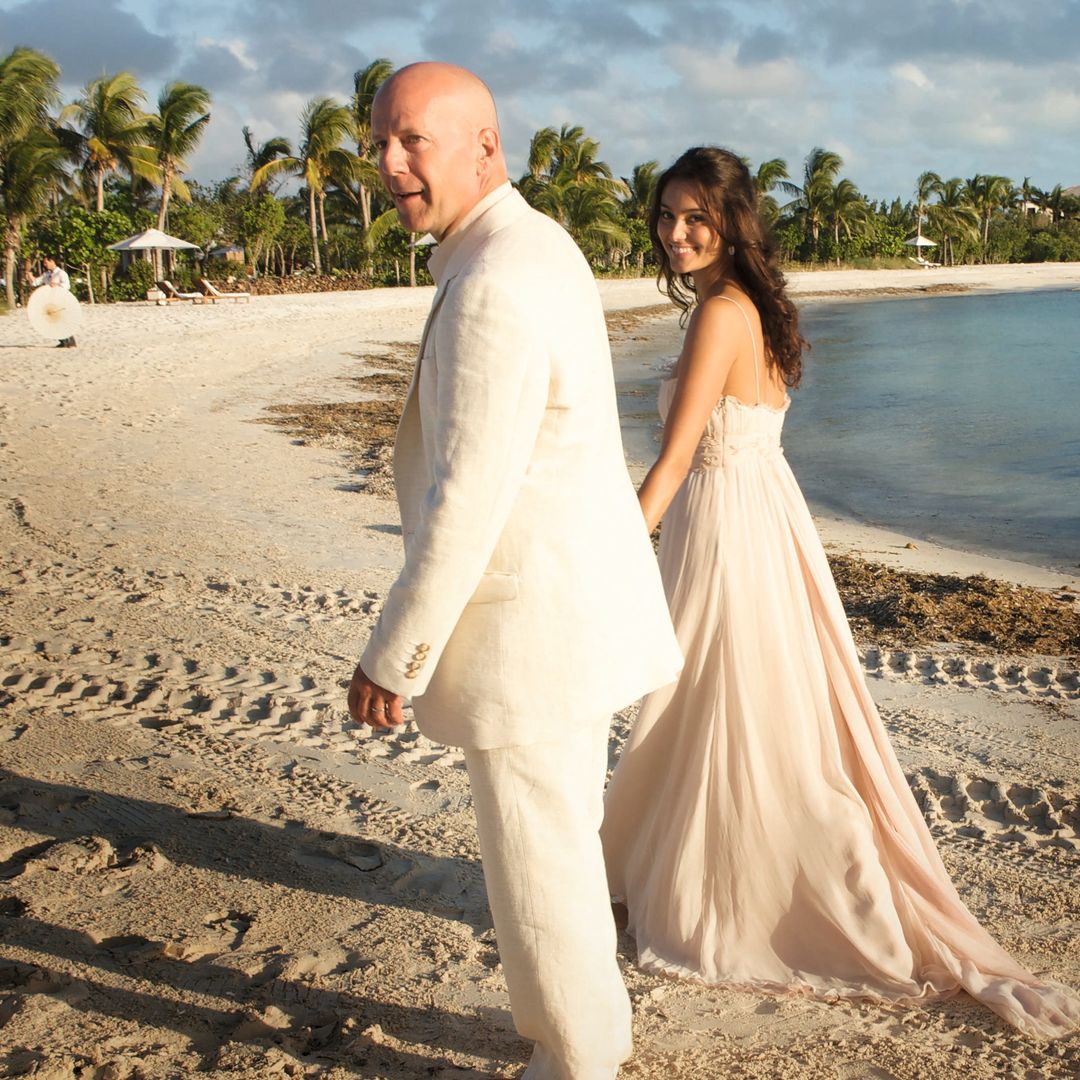 Bruce y Emma caminando descalzos por la playa el día de su boda, celebrada en Parrot Cay, en las Islas Turcas y Caicos