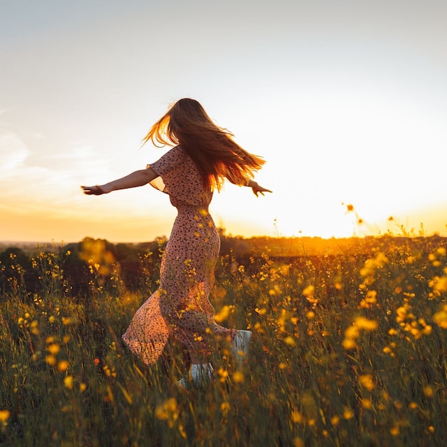Mujer bailando en un campo de flores