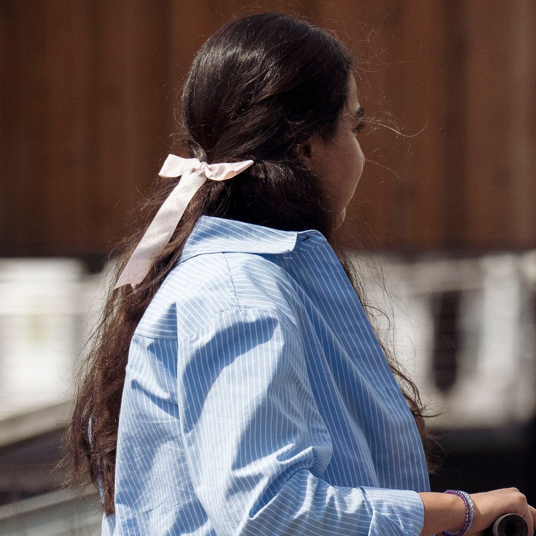 Invitada a la Semana de la Moda de Copenhague con look azul y lazo como adorno de un semirrecogido