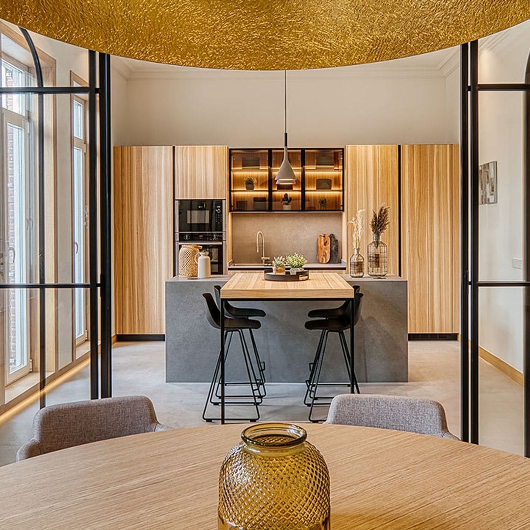 Una cocina con cerramiento para separar ambientes en una planta alargada y comunicada