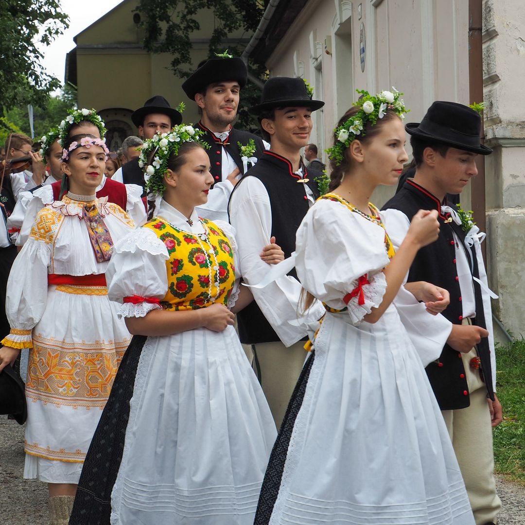 Jóvenes visten trajes tradicionales populares eslovacos durante la procesión de bodas en el pueblo de Vlkolínec, Patrimonio de la Humanidad