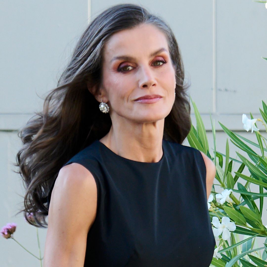 La reina Letizia llegando a la cena en honor a Mariano de Cavia, Mingote y Luca de Tena en Madrid con vestido negro y pelo suelto.