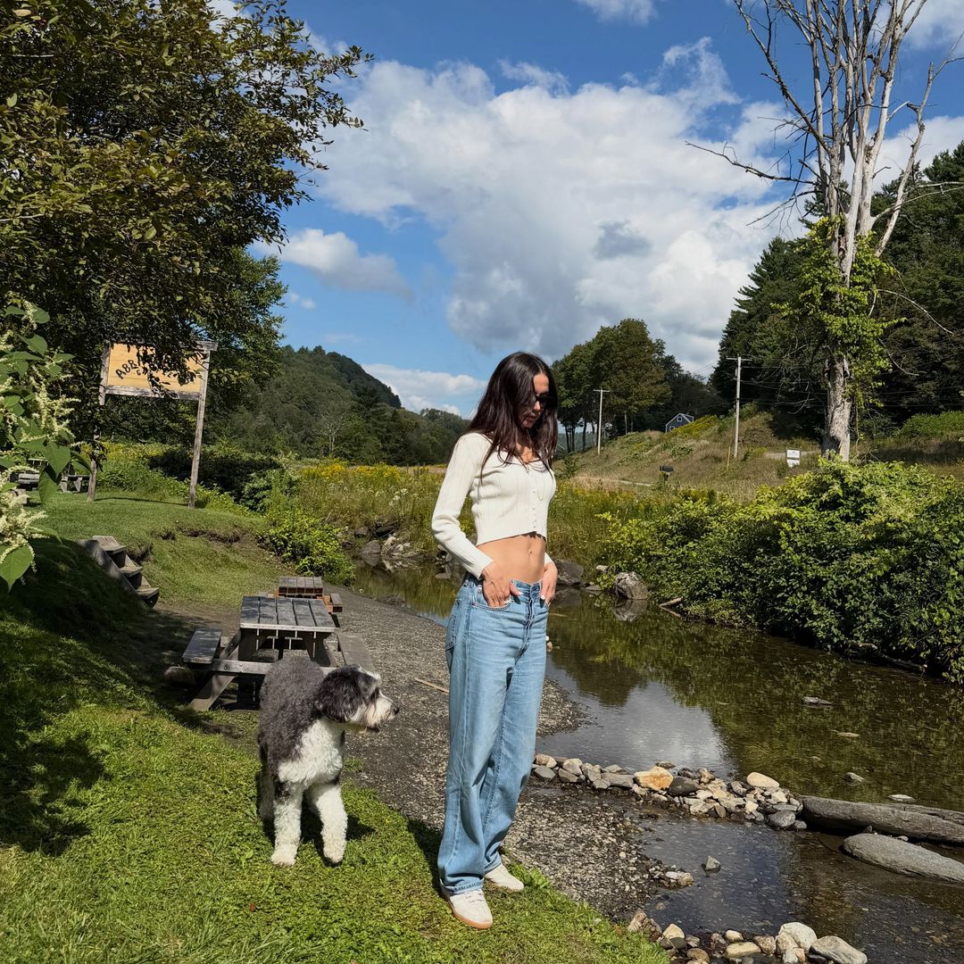 Ana de Armas en la naturaleza con su perro, vaqueros, camiseta de manga larga y pelo suelto