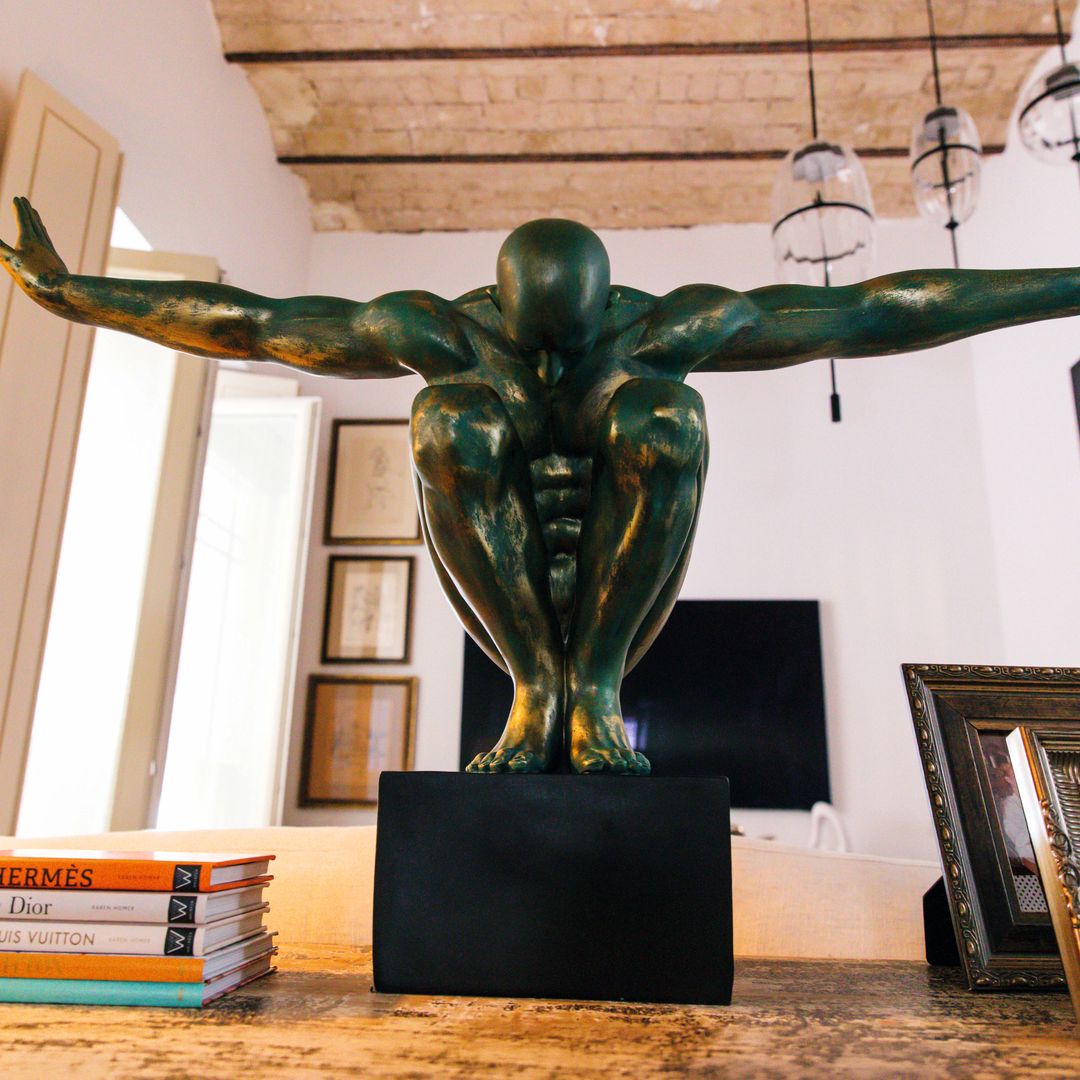 Escultura decorativa de resina tipo "Athlet", en acabado bronce verde sobre base negra