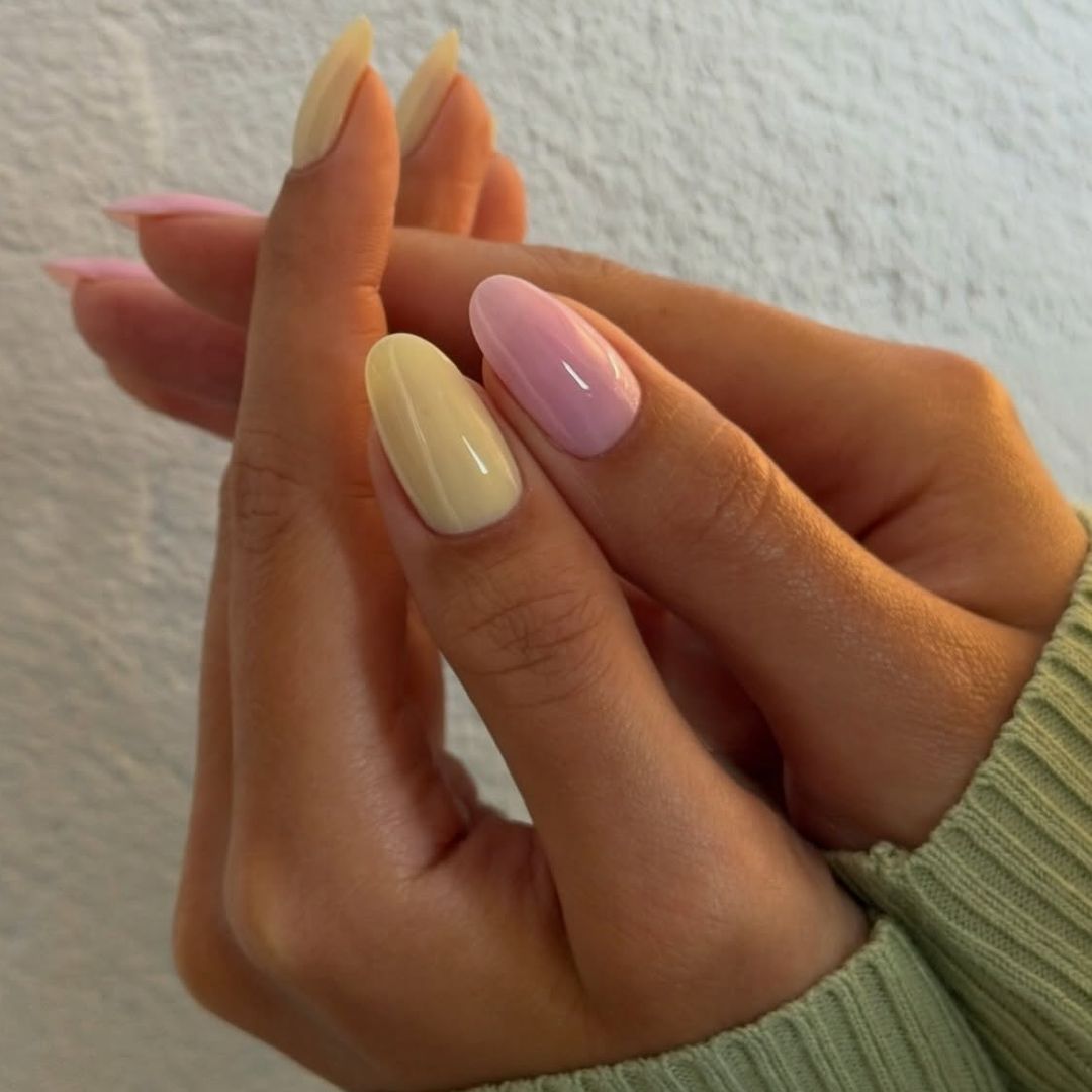 Manicura pastel amarillo en una mano y rosa en la otra