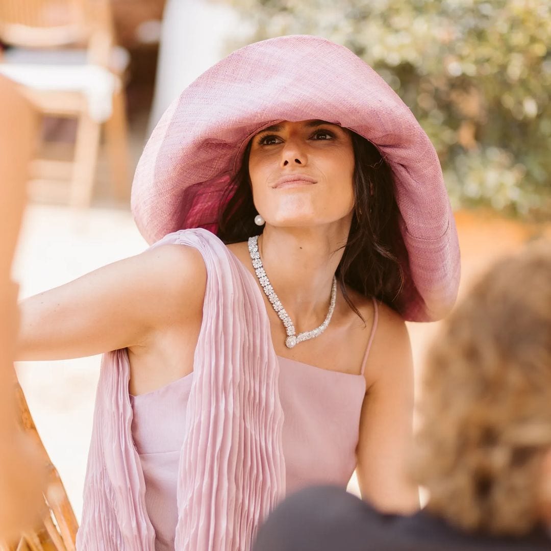 Ser la hermana de una novia sevillana y triunfar sin eclipsarla: un vestido de invitada rosa, pamela y diamantes familiares