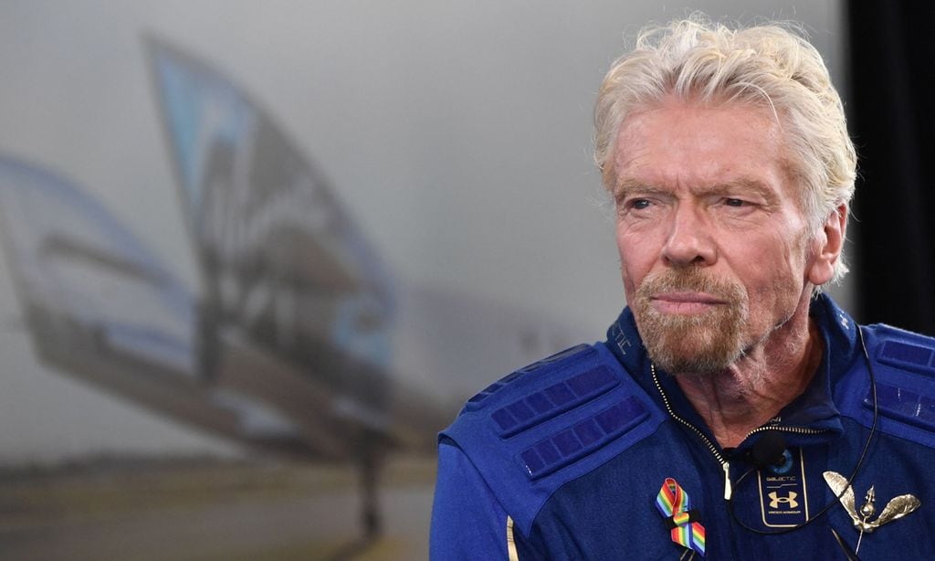 Richard Brandson con aspecto serie, detras de el podemos ver el avión usado por Virgin Galactic para sus vuelos