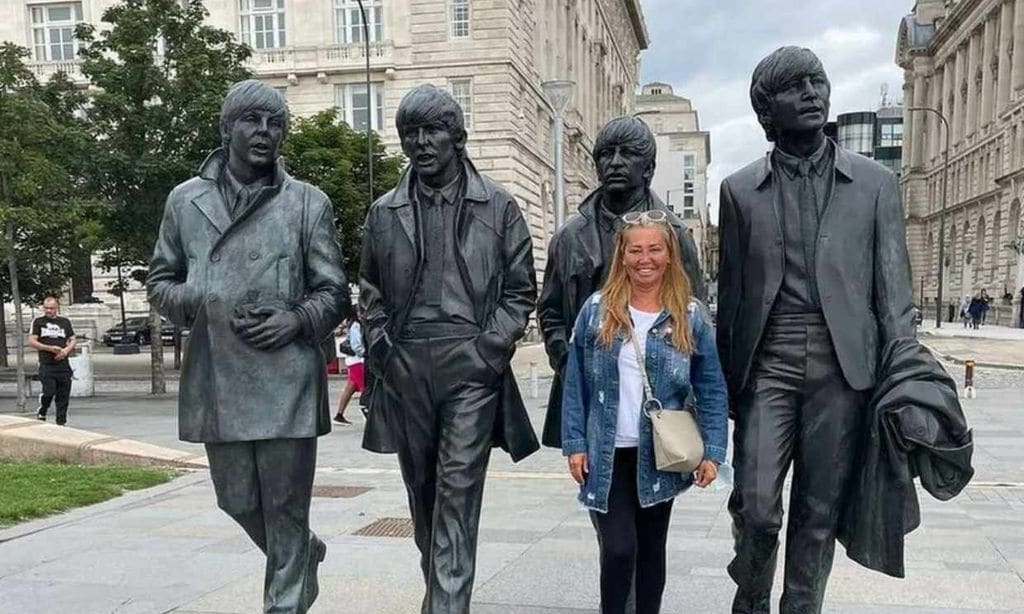 Belén Esteban posa junto a la estatua de Los Beatles. 