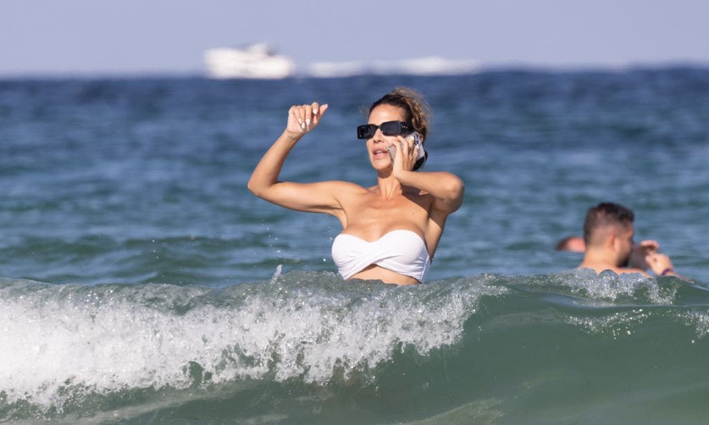 Tamara Gorro no se separa del móvil ni dentro del agua en la playa de Ibiza