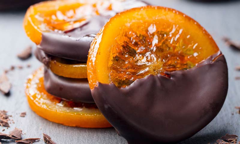 Ruedas de naranja confitada con chocolate fundido