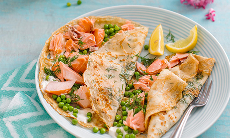 Crepes de salmón con crema agria y guisantes