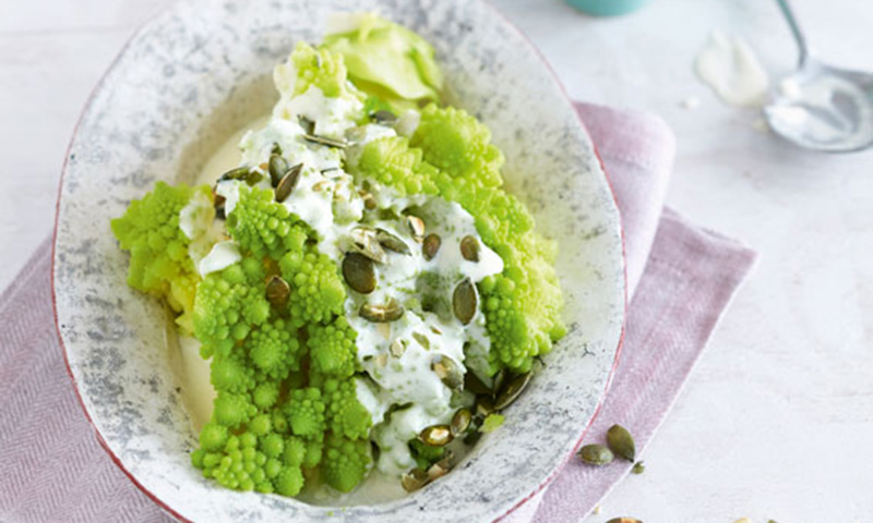 Romanesco con salsa de queso y pipas