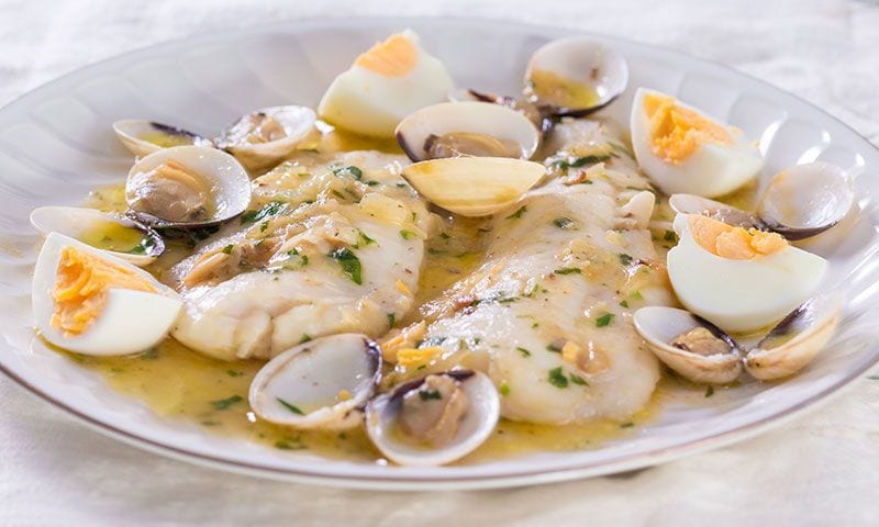 Merluza a la sidra con almejas y huevo duro