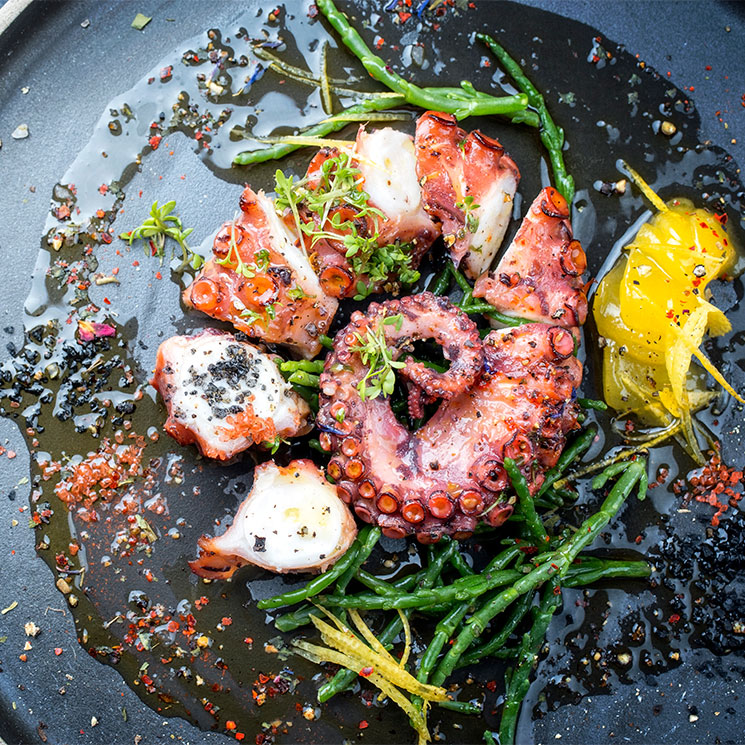 Pulpo braseado con salicornia, limón confitado y copos de chile