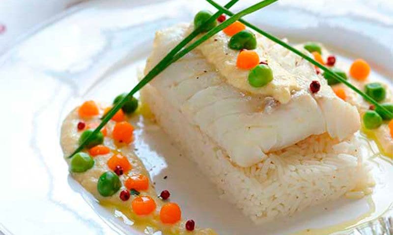 Taco de bacalao sobre cama de arroz y verduras