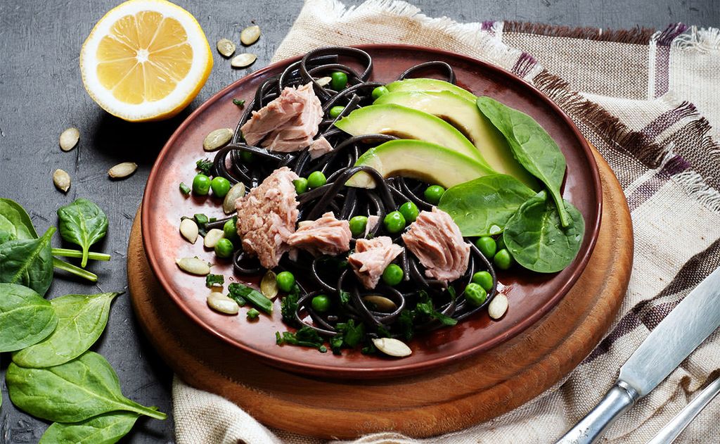 Ensalada de pasta negra con espinacas, aguacate y pipas de girasol