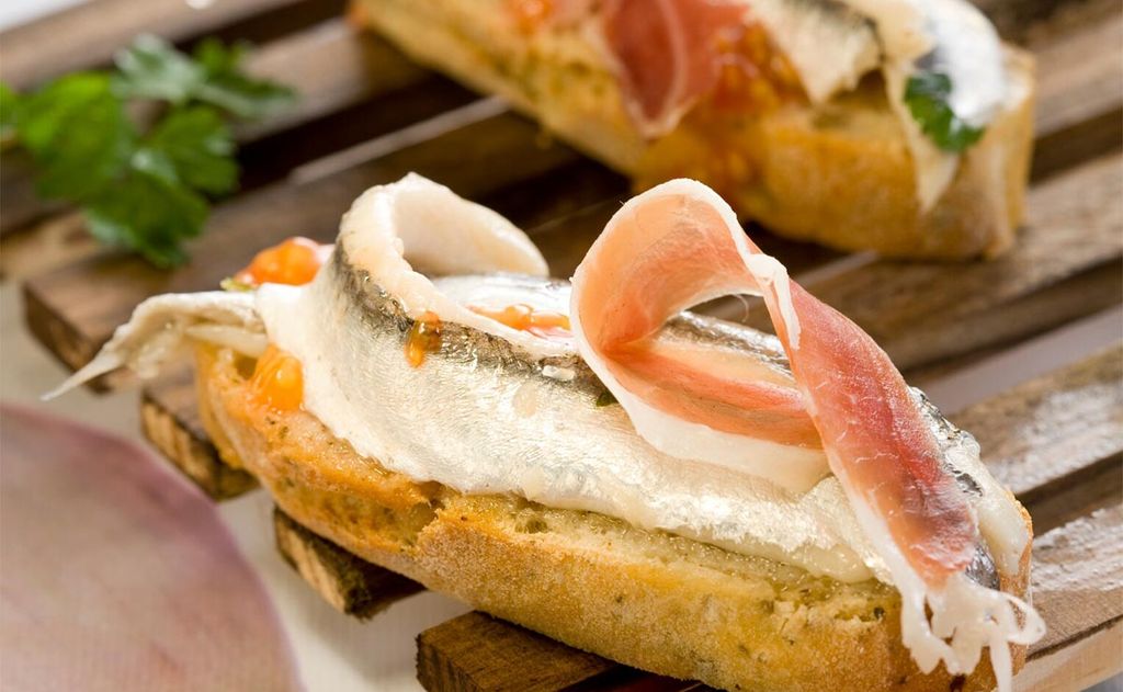 Canapé de boquerones en vinagre, jamón y tomate