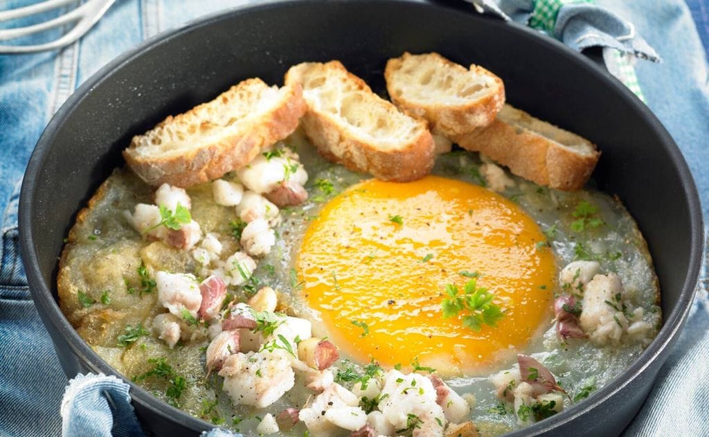 Huevo de avestruz con bacalao salteado al ajo