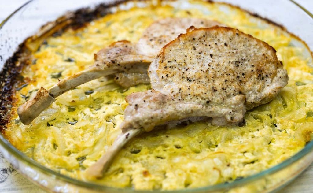Chuletas de cordero sobre cebolla y puerro cremosos