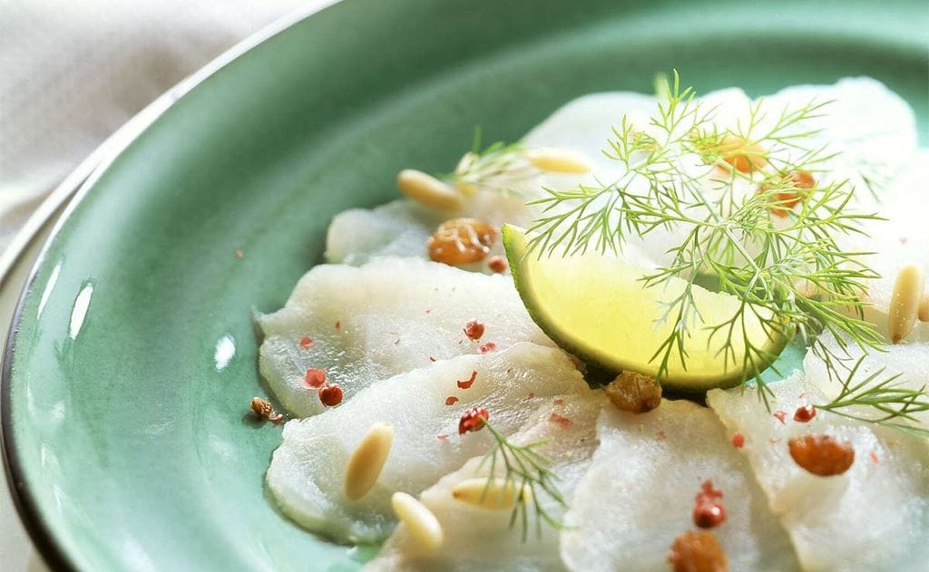 Carpaccio de esturión con pasas y piñones